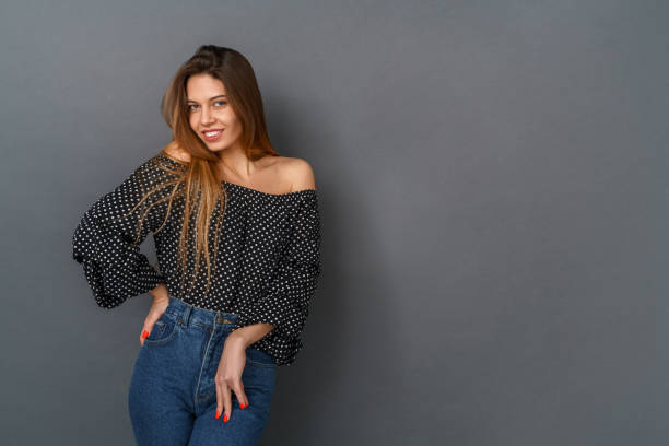 istock Young woman casual studio isolated on gray posing looking camera shy 1206705434