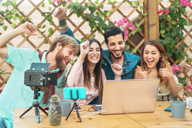 istock Young friends doing live stream video on internet blog using computer and smartphone cam - Millennial people having fun networking with new technology - Youth generation and social media concept 1206705569