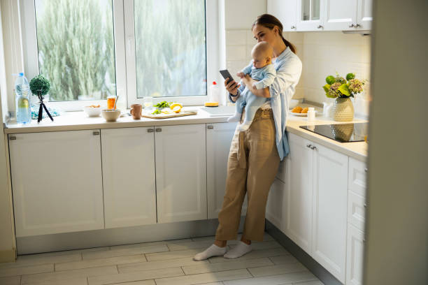 istock Pretty young mother with her baby using smartphone 1206708431