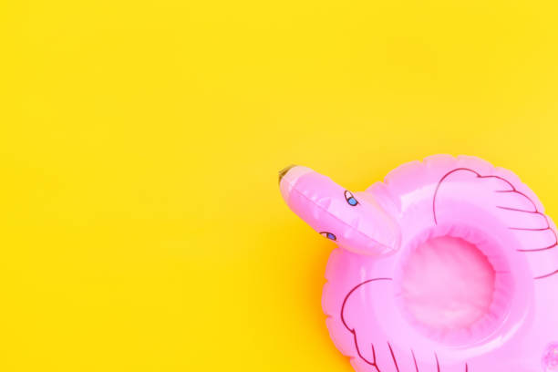 istock Summer beach composition. Simply minimal design with pink Inflatable flamingo isolated on yellow background. Pool float party, trendy celebrity fashion concept. Flat lay top view copy space 1206708541
