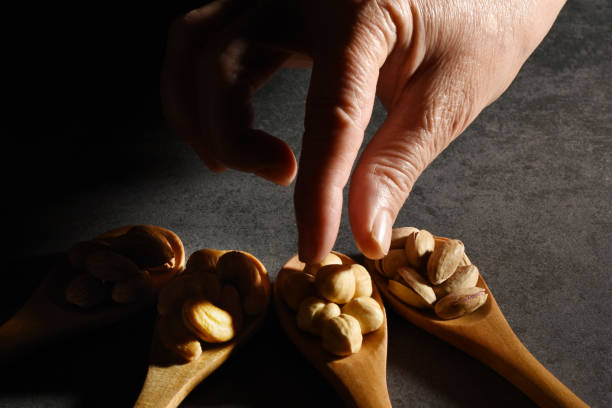 Close up a woman hand reach out mixed nuts