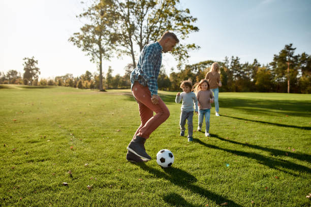 istock A nurturing and creative world. Happy family playing with a ball on meadow 1206716254
