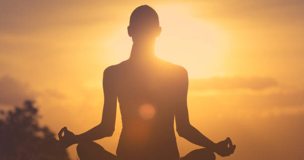 istock Woman meditating at sunrise 1206716404