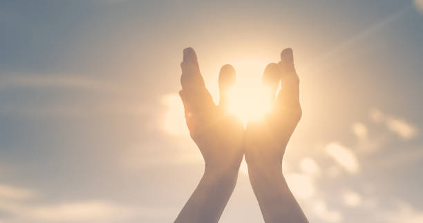 pessoas segurando o sol na palma da mão se sentindo energizadas. espiritual, mente, conceito corporal. - iluminação espiritual - fotografias e filmes do acervo