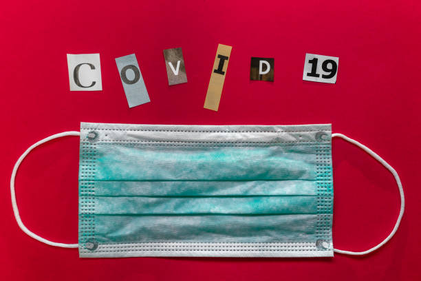 istock Protective mask with COVID-19 text on red background 1206716448