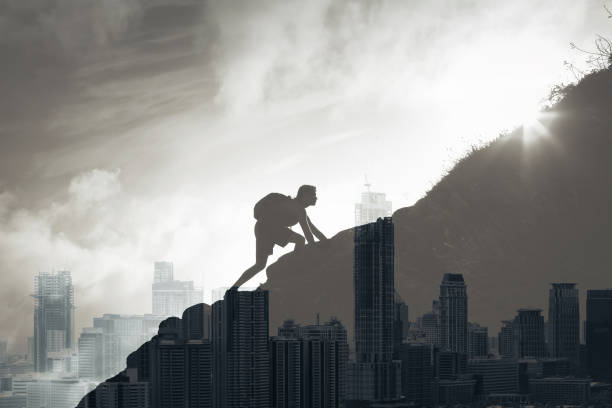 istock Determined man climbing up mountain overlooking the city. 1206717324
