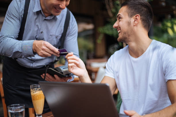 istock Joyful wealthy man paying for his drink 1206718959
