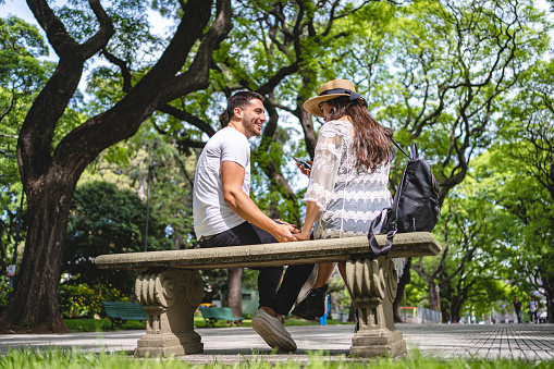 Boyfriend and girlfriend having fun on a date together in a public park