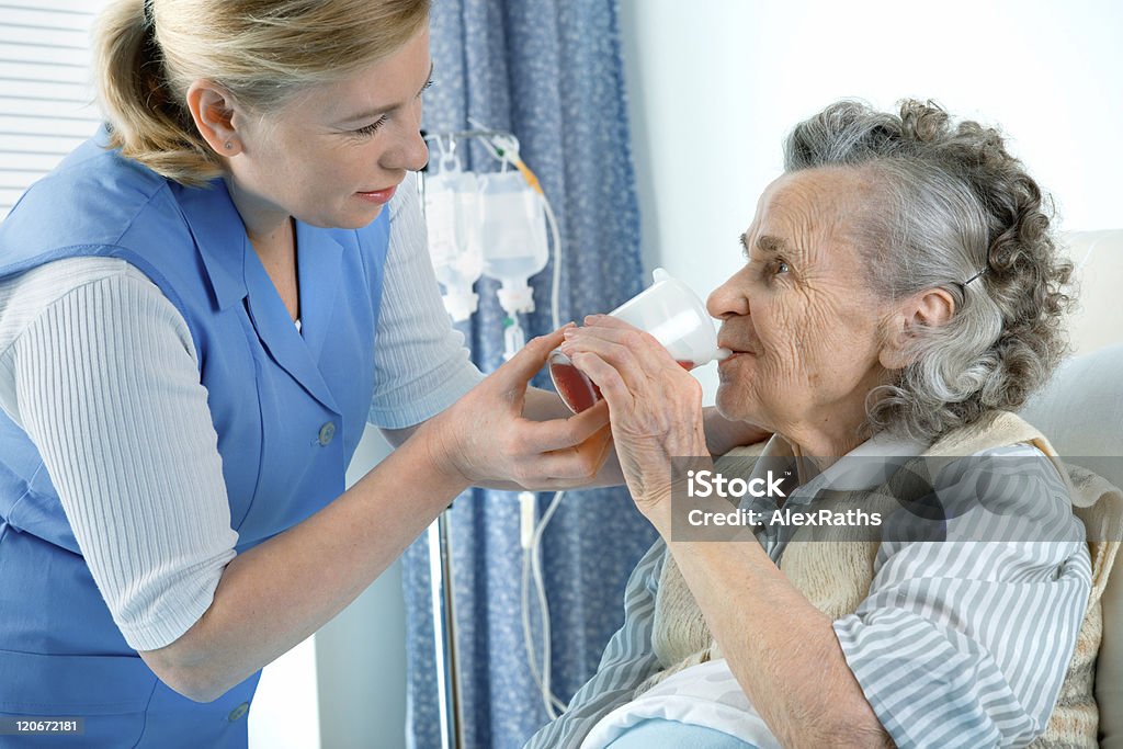 Młoda kobieta z starszą kobietę z drinkiem - Zbiór zdjęć royalty-free (Karmić)