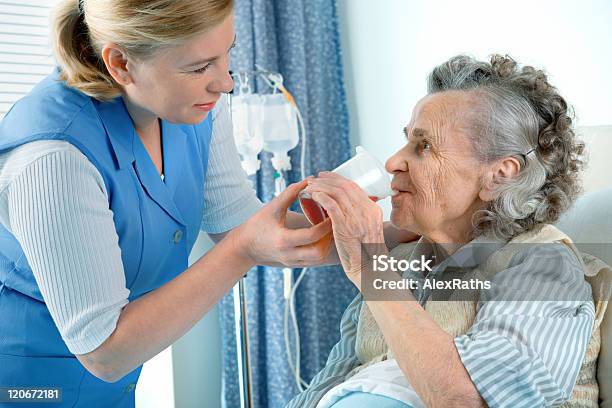 Młoda Kobieta Z Starszą Kobietę Z Drinkiem - zdjęcia stockowe i więcej obrazów Karmić - Karmić, Senior, Szpital