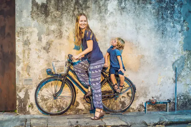 Mother and son on a bicycle. Public street bicycle in Georgetown, Penang, Malaysia.