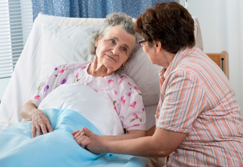 Senior female is being visited by the daughter in hospital.