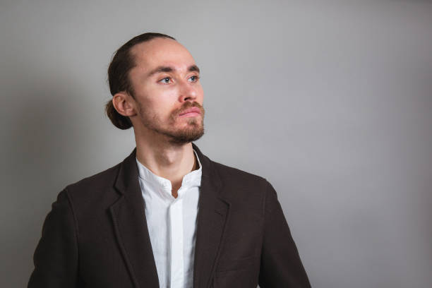 istock Serious businessman looking away and thinking on gray background 1206723575