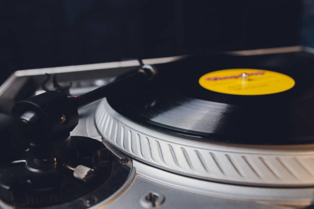 istock Dj hands on equipment deck and mixer with vinyl record at party. 1206728934