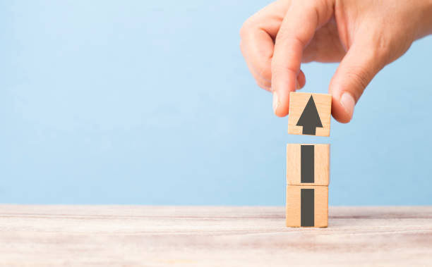 istock hand stacking cubes in a row, arrow symbol pointing up 1206729083