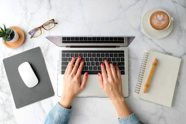 istock Flat lay workspace. Woman working on laptop coffee cup, smartphone, computer, notebook, planner and stationary with copy space on marble table background. Top view. modern style. 1206729961