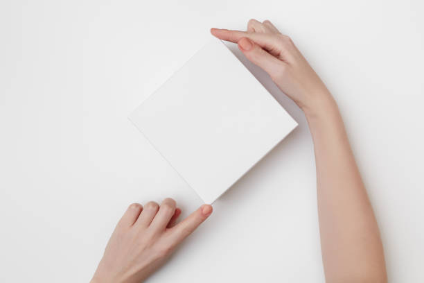 istock Mock up of white present box in women's hands on the white background 1206731599