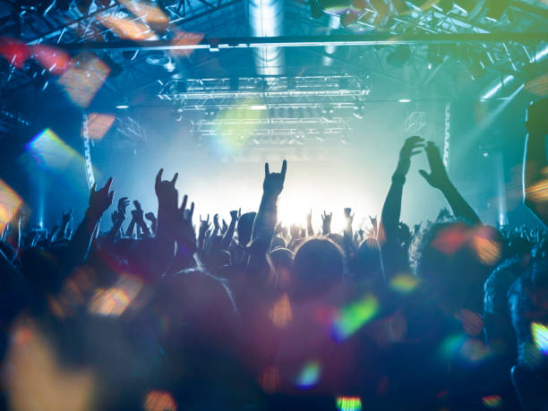 Concert crowd Colourful concert stage inside a venue, people silhouettes are visible clapping popular music concert stock pictures, royalty-free photos & images