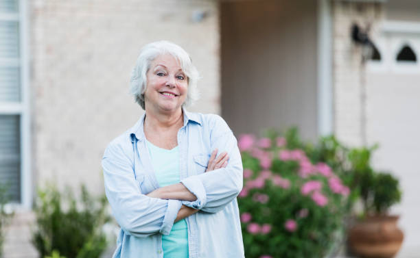 istock Senior woman standing in front of home 1206736344