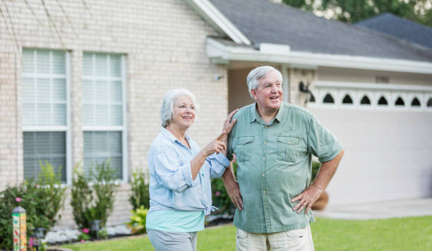 istock Senior couple standing in front of home 1206736984