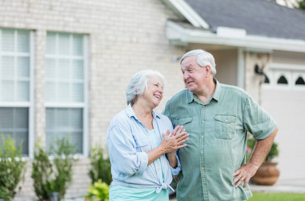 istock Senior couple standing in front of home 1206736986