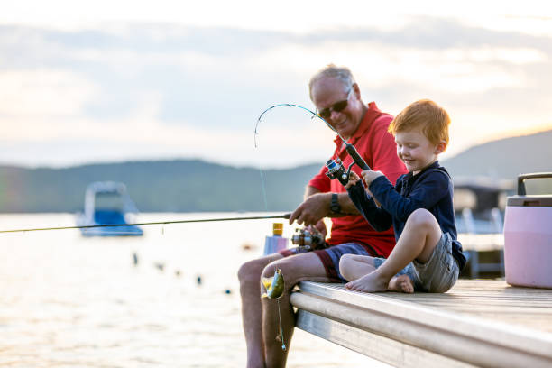 дедушка и внук рыбалка на закате летом - fishing active seniors family senior adult стоковые фото и изображения