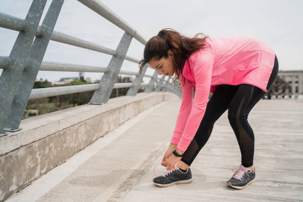istock Athletic woman  tying her shoelaces. 1206739987