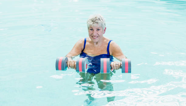 istock Senior woman doing water aerobics in pool 1206740850
