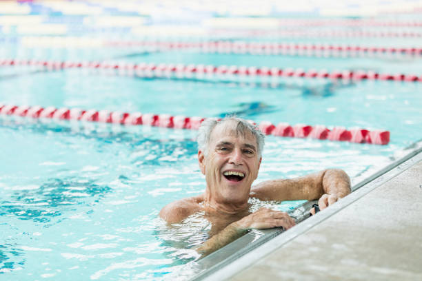 istock Senior man in pool taking break from swimming laps 1206740892