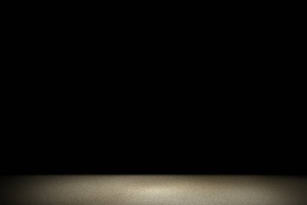 istock Light shining down on brown concrete floor in dark room with copy space, abstract background 1206740931
