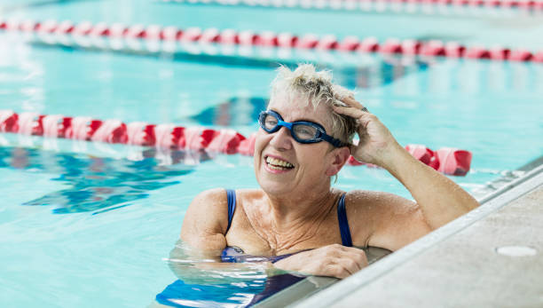 istock Senior woman in pool taking break from swimming laps 1206740971