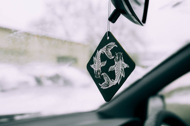 purificador no carro na forma de um desenho do sinal zodíaco de um peixe em um quadrado preto no fundo de um para-brisa coberto de neve. - deodorizing - fotografias e filmes do acervo