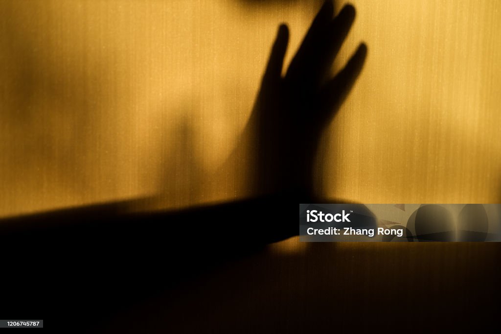A hand gesture showing refusal in silhouette on the wall Sexual Assault Stock Photo