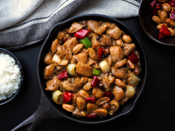Delicious kung pao chicken with pepper, shallots and peanuts in a wok pan. Stir-fried Chinese traditional dish, eat with rice. Top view. sichuan province stock pictures, royalty-free photos & images