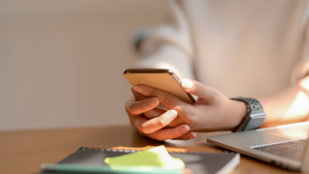 istock Close-up view of girl using her smartphone while sitting in co-working space 1206750014
