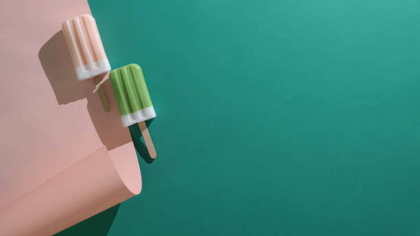 Top view of green tea and strawberry flavour popsicles and copy space on flat lay green and pink background