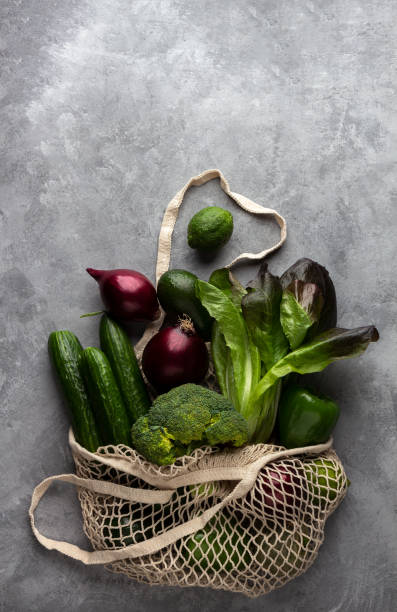 istock Green groceries in a string bag on a gray background 1206751888