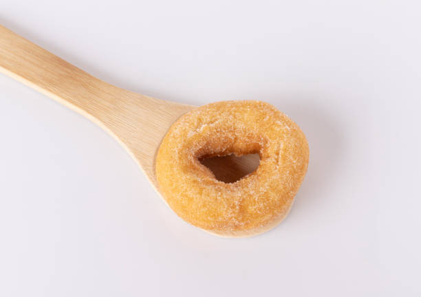 Donuts on a wooden spoon on a white background.