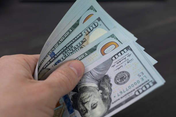istock Man pays, holds money, dollars in hand 1206764861