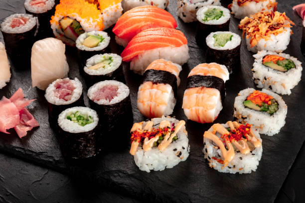 istock Large sushi set on a black background. Many different maki, nigiri and rolls 1206767879