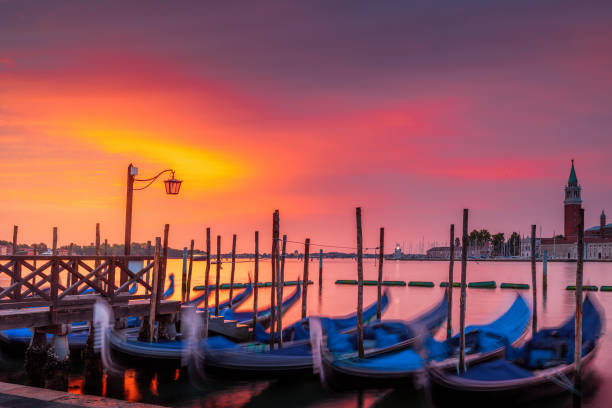 Colorful Sunrise over Venice Gondolas and San Giorgio island under a dramatic sky at sunrise in Venice, Italy venice italy grand canal honeymoon gondola stock pictures, royalty-free photos & images