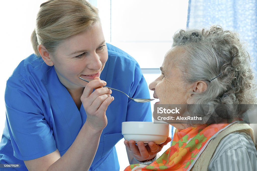 Care senior woman 90 years old being fed by a nurse Feeding Stock Photo