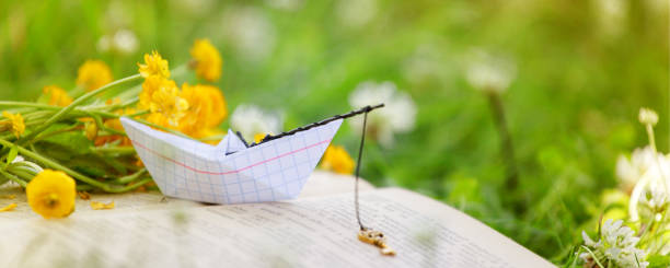 istock Open book outdoor. Knowledge is power. Book in a spring summer forest or garden, yard, concept of studying, dreaming, rest time, romance relax, banner 1206770769