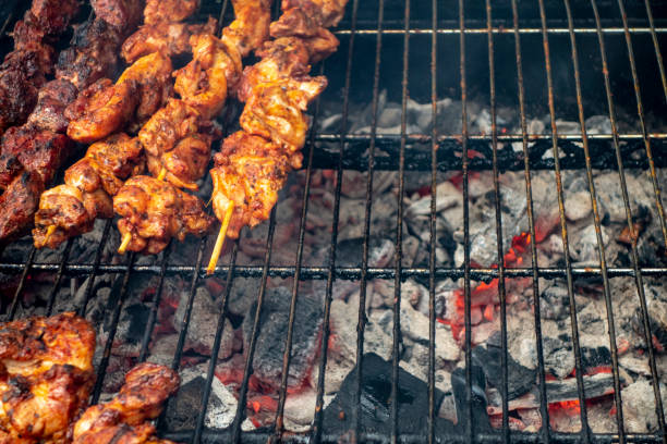 Overhead view of marinaded chicken skewers on outdoor backyard with red hott charcoal grill chicken cooking and grilling on a red hot charcoal open grill hott stock pictures, royalty-free photos & images