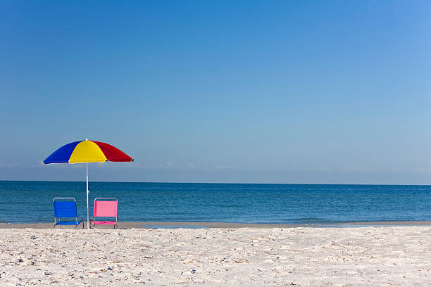 istock Colorful Beach Umbrella with Pink and Blue Deckchairs 120677231