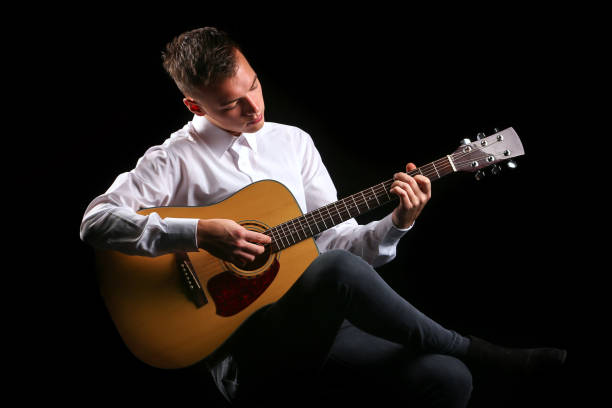 istock Young men playing the guitar with black background 1206774893