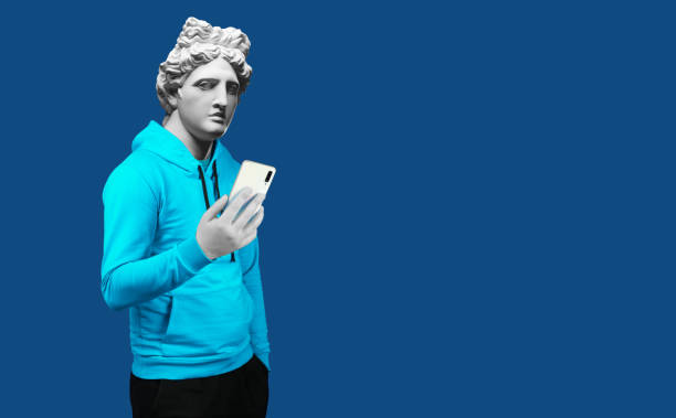 istock Modern art collage. Concept portrait of a man  holding mobile smartphone using app texting sms message. Gypsum head of of Apollo. Man in suit. On a blue background. 1206775604