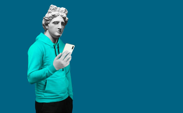 istock Modern art collage. Concept portrait of a man  holding mobile smartphone using app texting sms message. Gypsum head of of Apollo. Man in suit. On a blue background. 1206775605