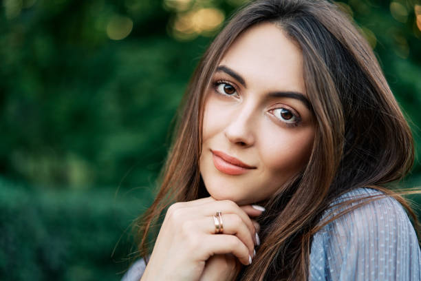 istock Young beautiful woman outdoors on green background summer nature 1206776210