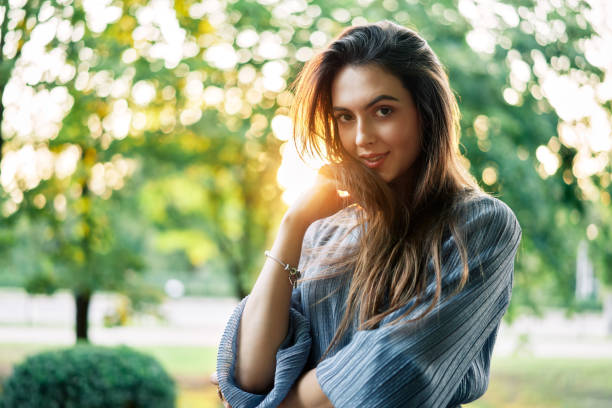 istock Young beautiful woman outdoors on green background summer nature 1206776216